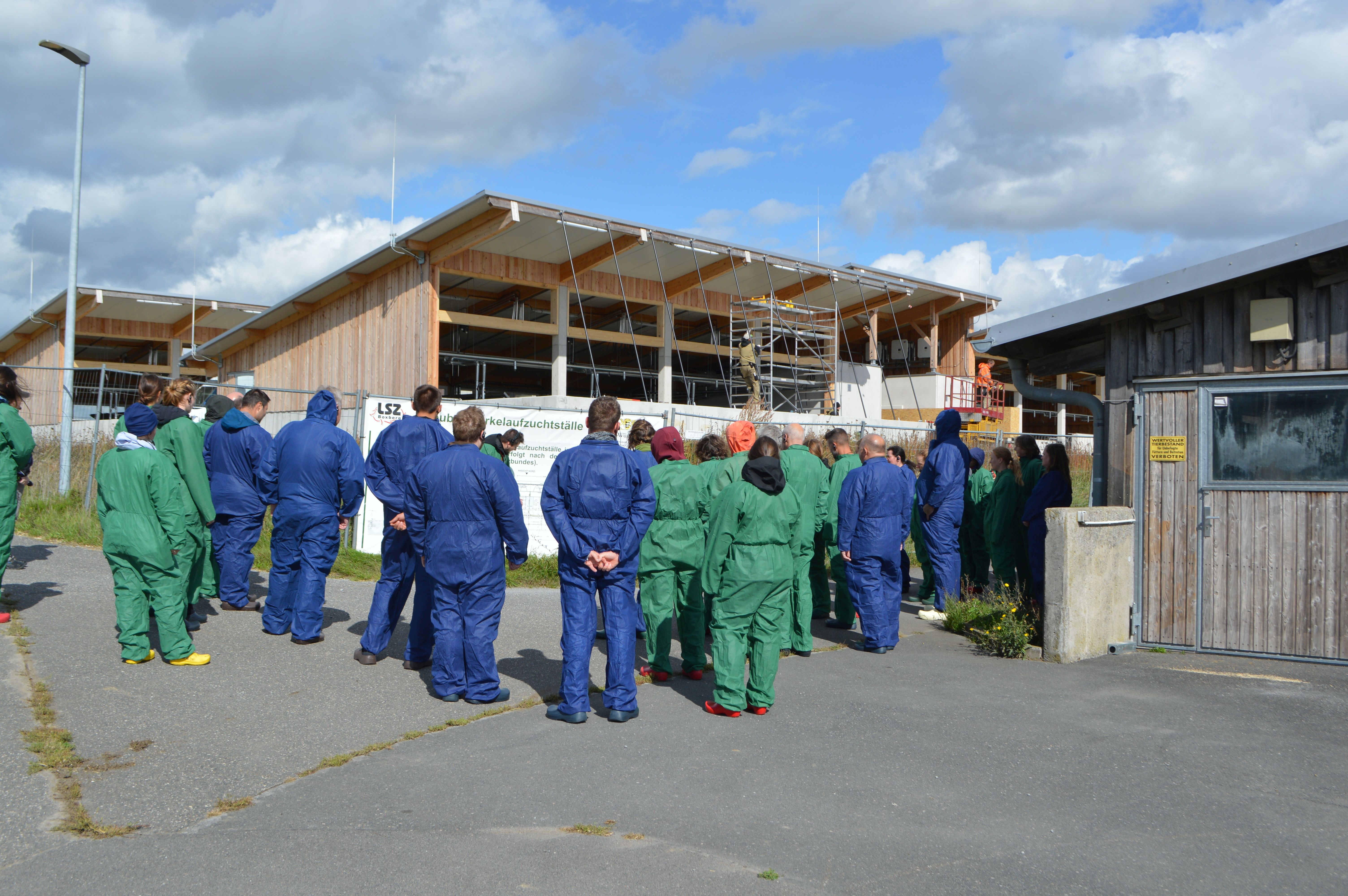 Das Bild zeigt eine Gruppe Menschen für einem neu gebauten Stall
