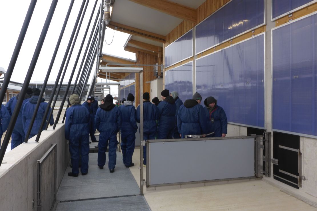 Das Bild zeigt eine Gruppe Menschen in einem neu gebauten Stall